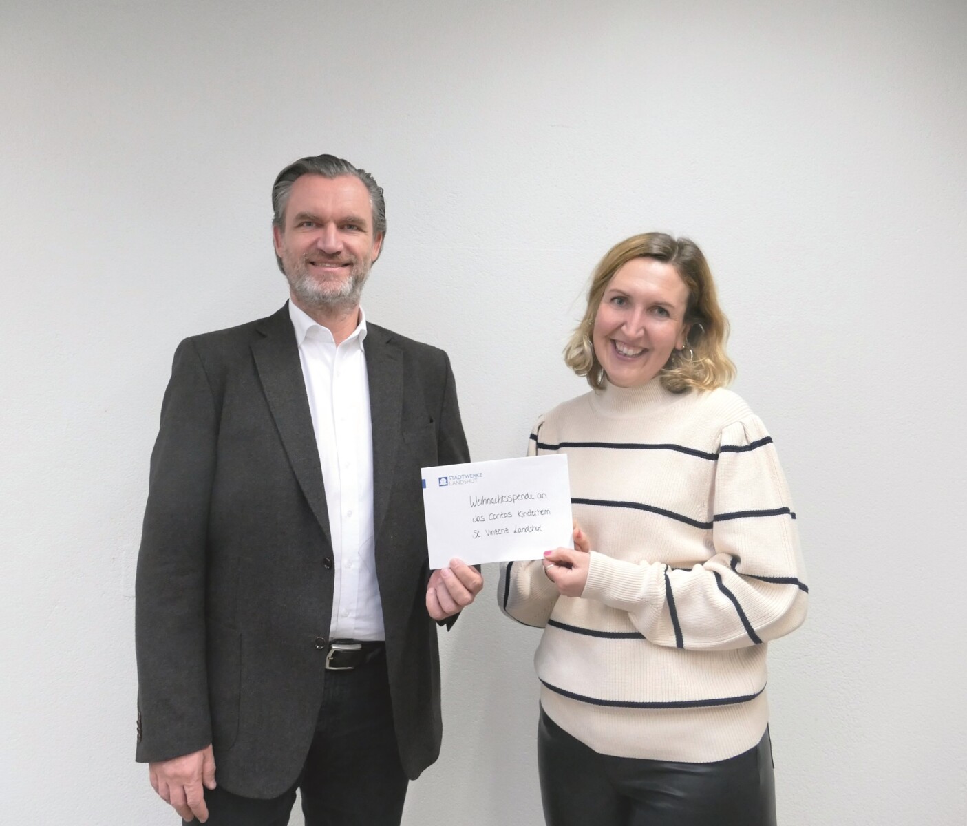 Werkleiter überreicht eine Weihnachtsspende.