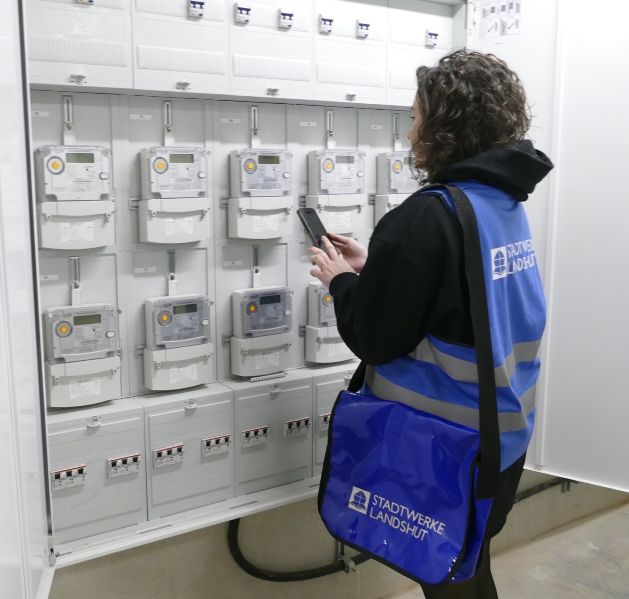 Ableser beim Zählerablesen im Mehrfamilienhaus Ableser vor einem Zählerschrank