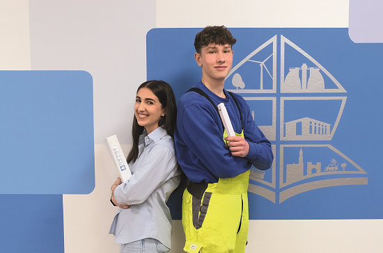 Ausbildung Zwei Auszubildende der Stadtwerke Landshut stehen lächelnd Rücken an Rücken.