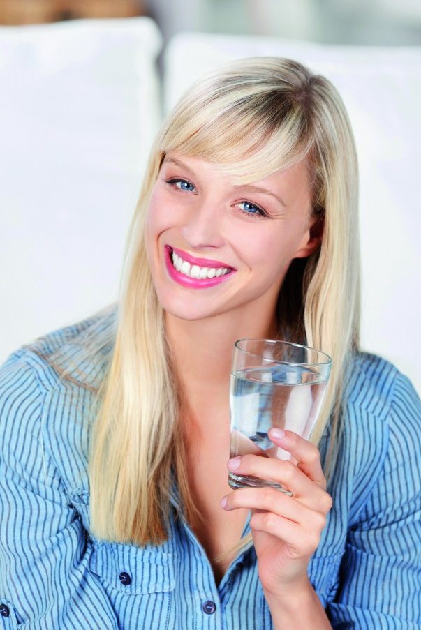 Frau mit Wasserglas in der Hand